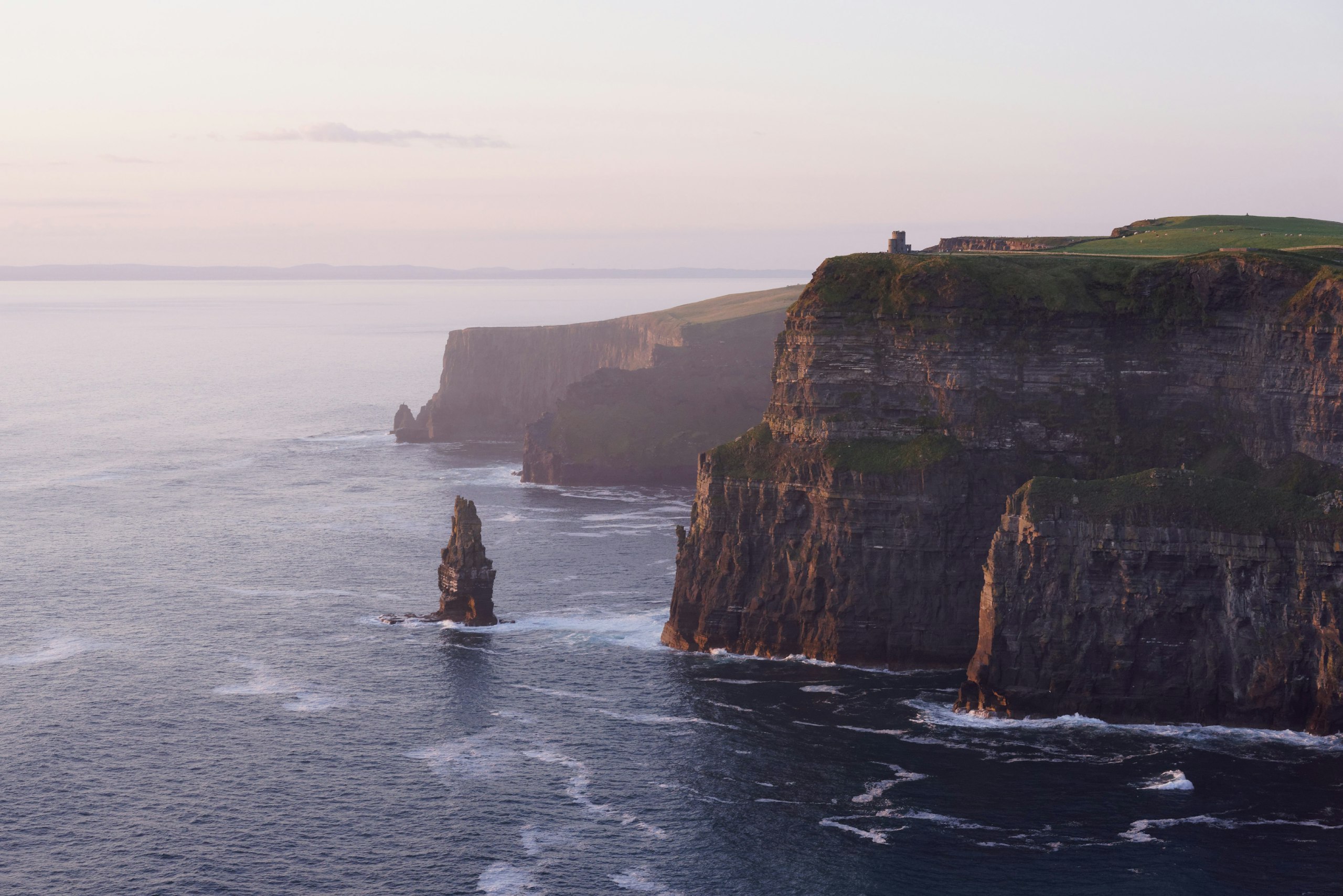 Rock formations along the Irish coastline under a pale sky