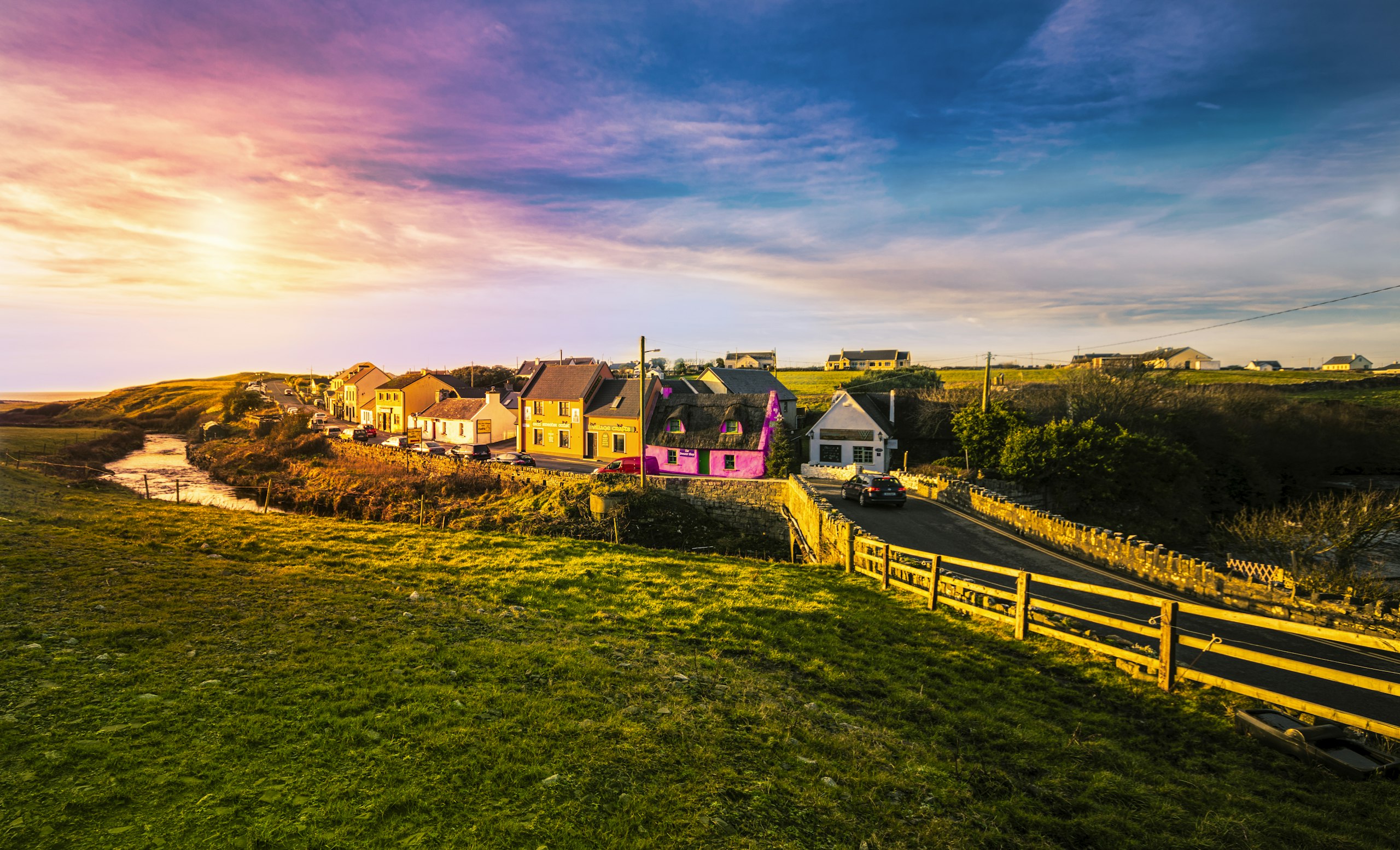 Houses gathered below rolling hills in rural Ireland